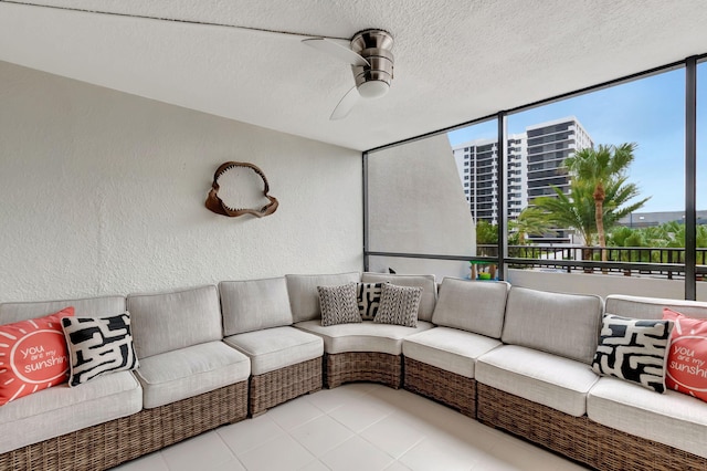 living room featuring ceiling fan, a wall of windows, and a textured ceiling