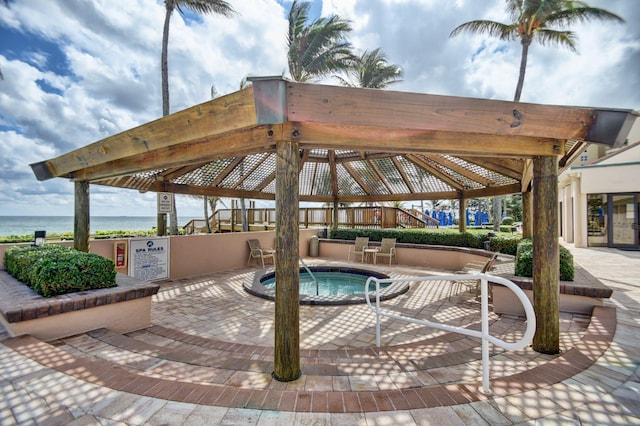 view of swimming pool featuring a gazebo, a water view, and a hot tub