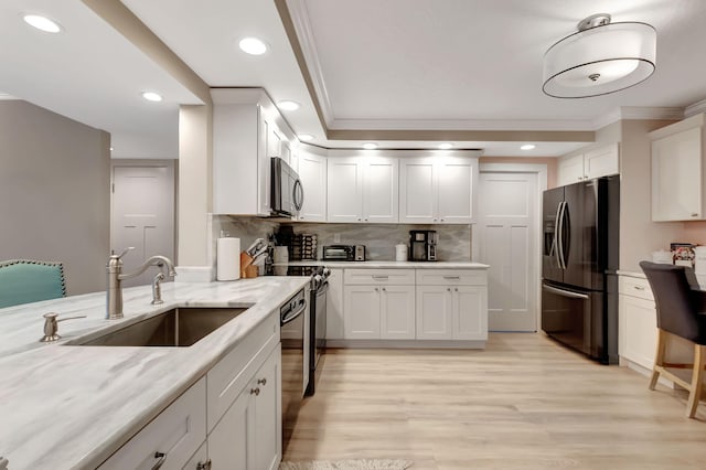 kitchen featuring decorative backsplash, white cabinetry, and stainless steel appliances