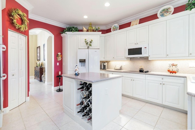 kitchen featuring decorative backsplash, white appliances, crown molding, a center island, and white cabinetry