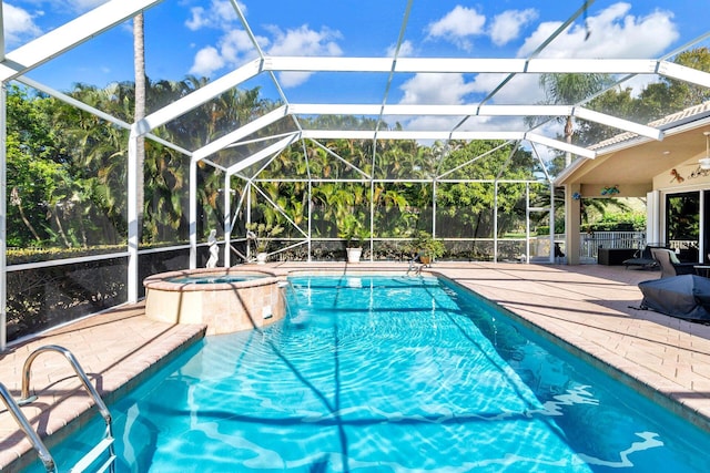 view of pool with an in ground hot tub, a patio, and glass enclosure