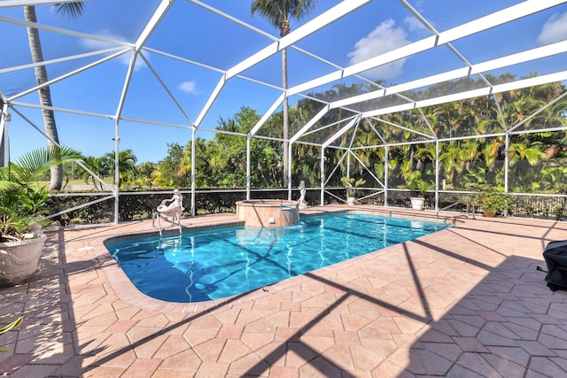 view of swimming pool with an in ground hot tub, glass enclosure, and a patio area