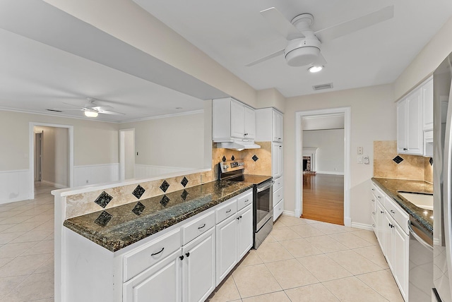 kitchen with backsplash, white cabinets, ceiling fan, appliances with stainless steel finishes, and kitchen peninsula