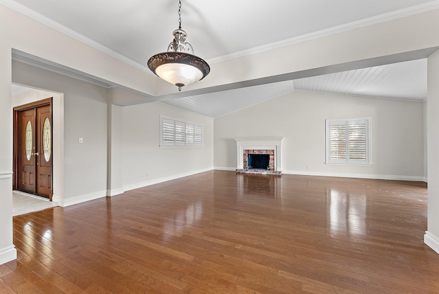 unfurnished living room featuring crown molding, wood-type flooring, vaulted ceiling, and a brick fireplace