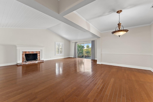 unfurnished living room featuring lofted ceiling with beams, wood-type flooring, ornamental molding, and a brick fireplace