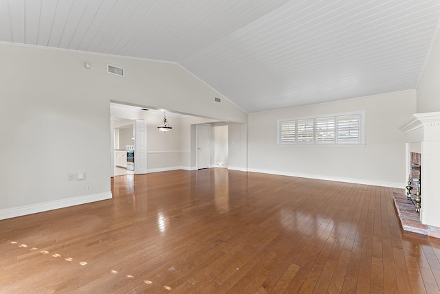 unfurnished living room with a brick fireplace, high vaulted ceiling, hardwood / wood-style floors, a chandelier, and ornamental molding