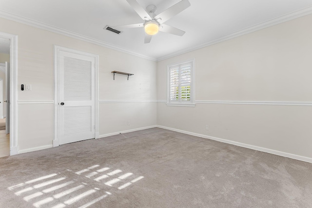 unfurnished bedroom with ceiling fan, light colored carpet, crown molding, and a closet