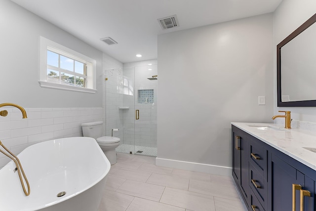 full bathroom featuring tile patterned flooring, separate shower and tub, toilet, vanity, and tile walls