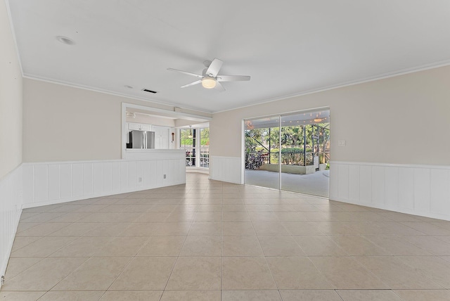 tiled empty room with ceiling fan and ornamental molding