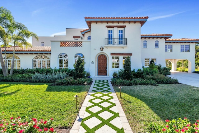 mediterranean / spanish house with a front yard and a balcony