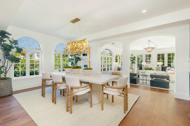 230 Argyle Rd, West Palm Beach, FL 33405 - dining space with a chandelier, light wood-style flooring, arched walkways, plenty of natural light, and recessed lighting