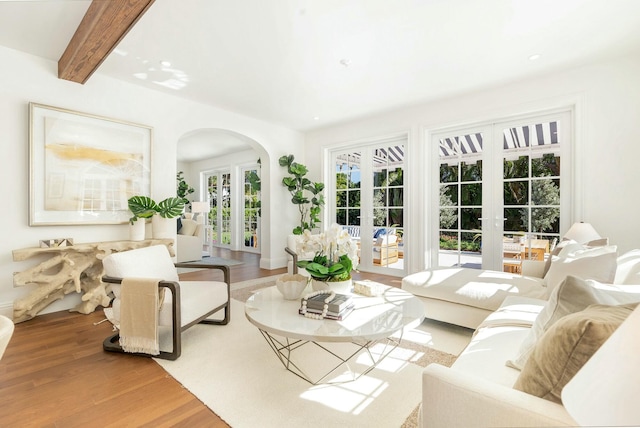230 Argyle Rd, West Palm Beach, FL 33405 - living room featuring french doors, arched walkways, wood finished floors, and beamed ceiling