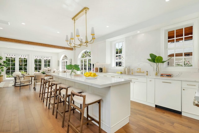 kitchen with a wealth of natural light, white cabinetry, and pendant lighting