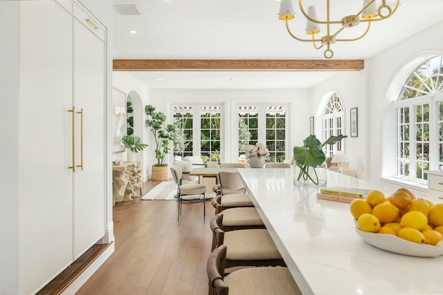 sunroom / solarium with a notable chandelier, beam ceiling, and french doors