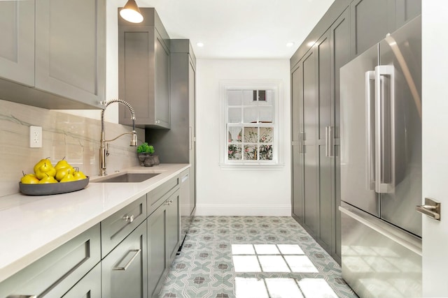 kitchen featuring sink, tasteful backsplash, gray cabinets, high quality fridge, and light tile patterned floors