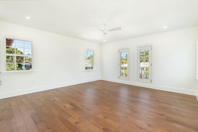 empty room with hardwood / wood-style floors, a wealth of natural light, and ceiling fan