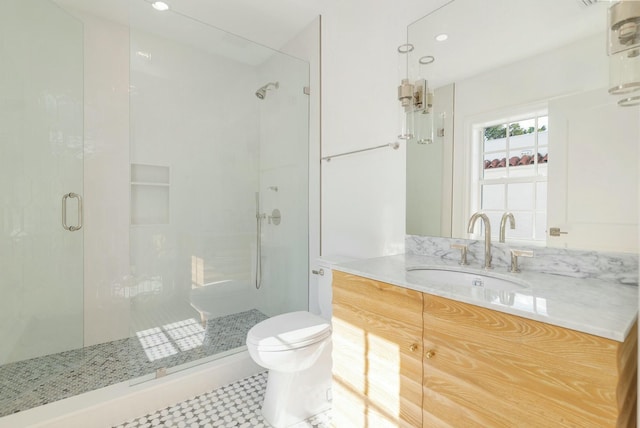 bathroom with tile patterned floors, vanity, toilet, and a shower with shower door