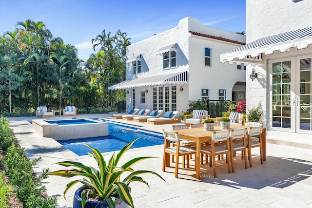 view of swimming pool with a patio area, an in ground hot tub, and french doors