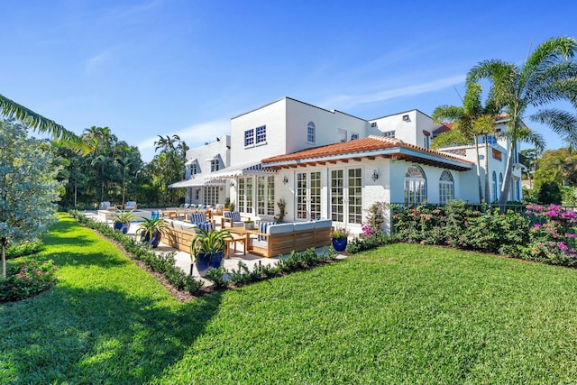 back of house with a yard, an outdoor living space, french doors, and a patio area