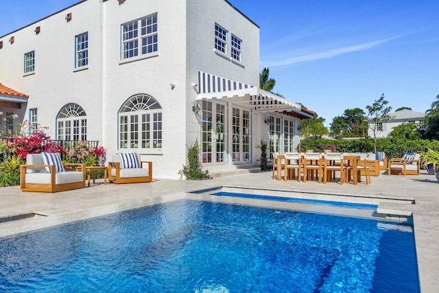 rear view of property with french doors and a patio