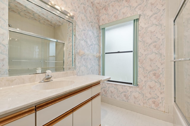 bathroom with tile patterned flooring, vanity, and enclosed tub / shower combo