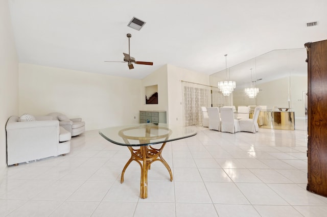 tiled dining area featuring ceiling fan with notable chandelier and vaulted ceiling