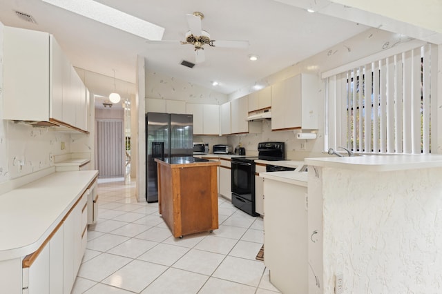 kitchen with white cabinetry, a center island, ceiling fan, lofted ceiling with skylight, and black appliances