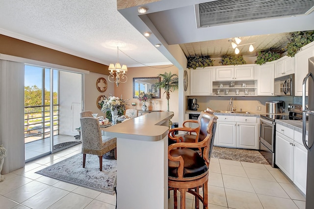 kitchen with white cabinetry, stainless steel appliances, an inviting chandelier, a textured ceiling, and decorative light fixtures