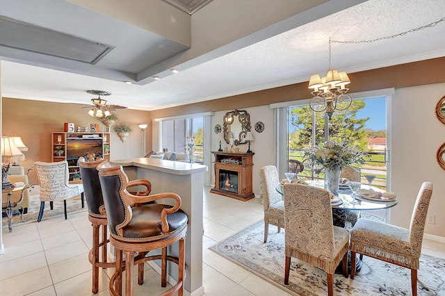 dining area featuring a textured ceiling, ceiling fan with notable chandelier, light tile patterned flooring, and crown molding