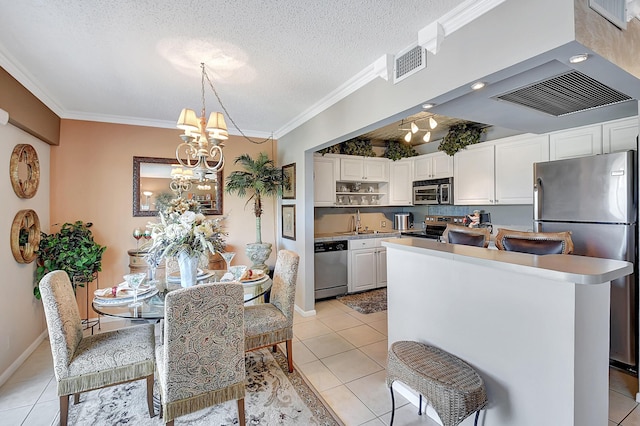 kitchen featuring white cabinets, appliances with stainless steel finishes, a textured ceiling, and light tile patterned floors