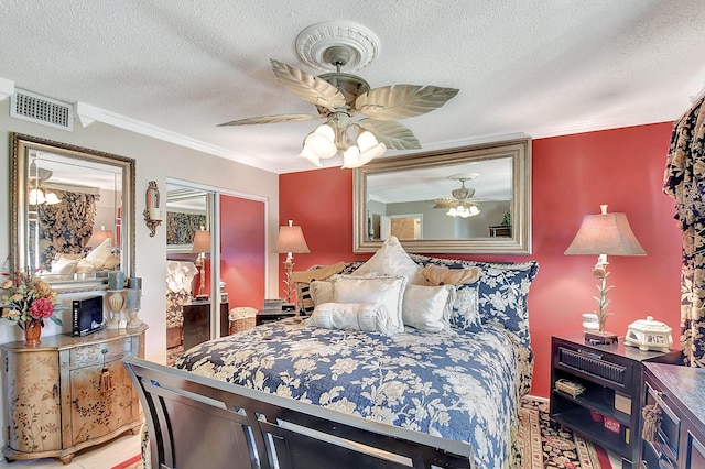 bedroom with a textured ceiling, a closet, ceiling fan, and crown molding