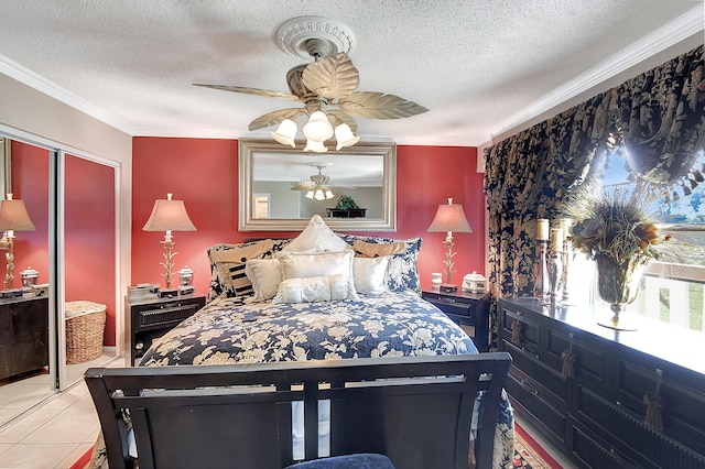 tiled bedroom featuring ceiling fan, ornamental molding, a textured ceiling, and a closet