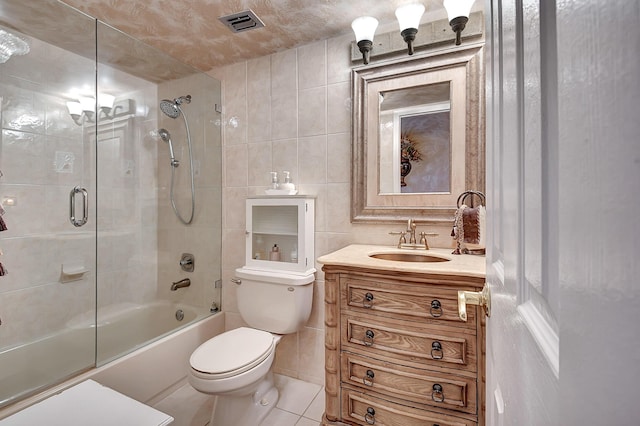 full bathroom featuring tile patterned flooring, vanity, toilet, and tile walls