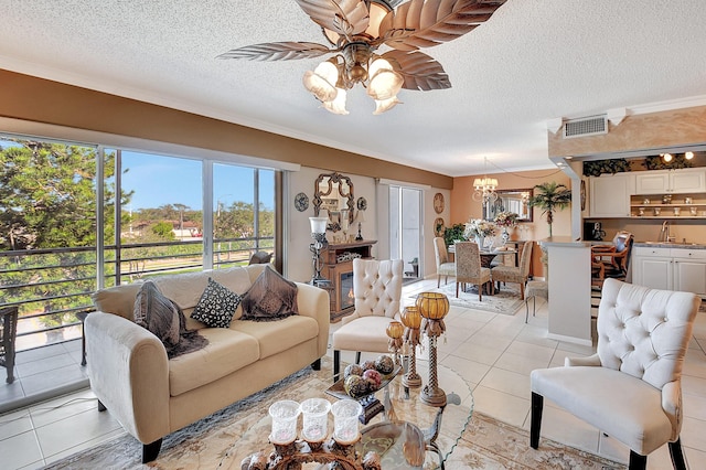 living room featuring ceiling fan with notable chandelier, crown molding, light tile patterned floors, and a textured ceiling