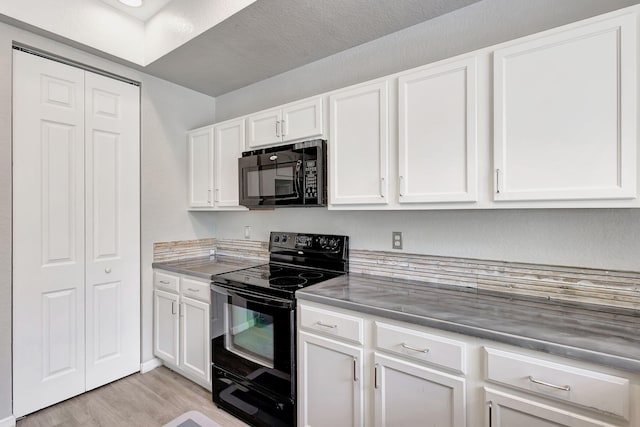 kitchen with white cabinetry, black appliances, a textured ceiling, and light wood-type flooring