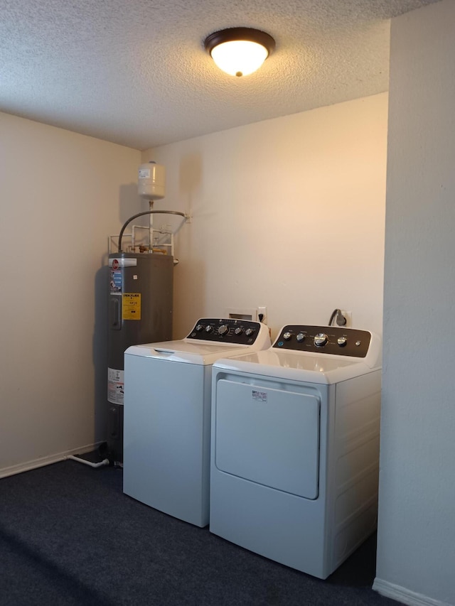 clothes washing area with laundry area, washing machine and clothes dryer, dark colored carpet, a textured ceiling, and water heater