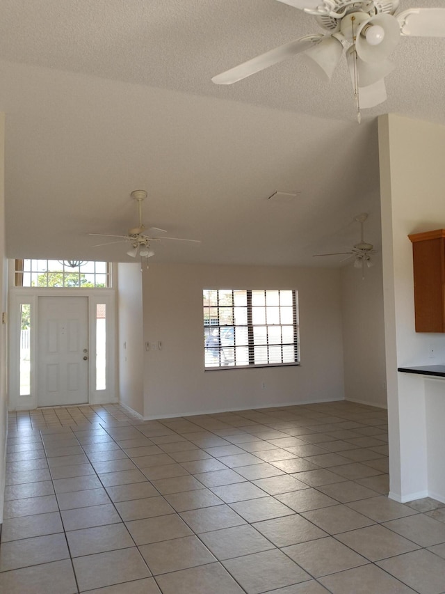 foyer featuring light tile patterned flooring, ceiling fan, and a textured ceiling