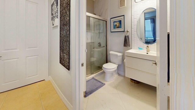 full bath with a shower stall, toilet, vanity, tile patterned floors, and baseboards