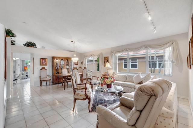 living room with light tile patterned floors, track lighting, and vaulted ceiling