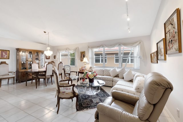 living room featuring light tile patterned floors, rail lighting, vaulted ceiling, and a notable chandelier