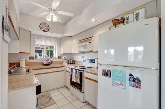 kitchen featuring ceiling fan, sink, light tile patterned flooring, and white appliances