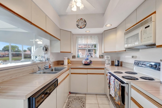 kitchen featuring light tile patterned flooring, white appliances, plenty of natural light, and sink