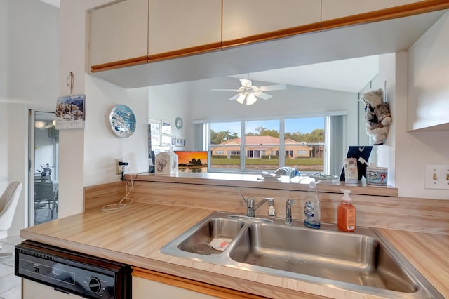 kitchen featuring sink, vaulted ceiling, light tile patterned floors, dishwashing machine, and butcher block counters