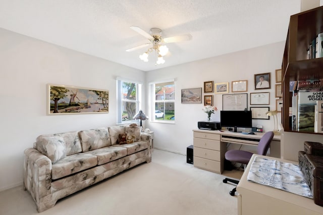 office space with light carpet, a textured ceiling, and ceiling fan