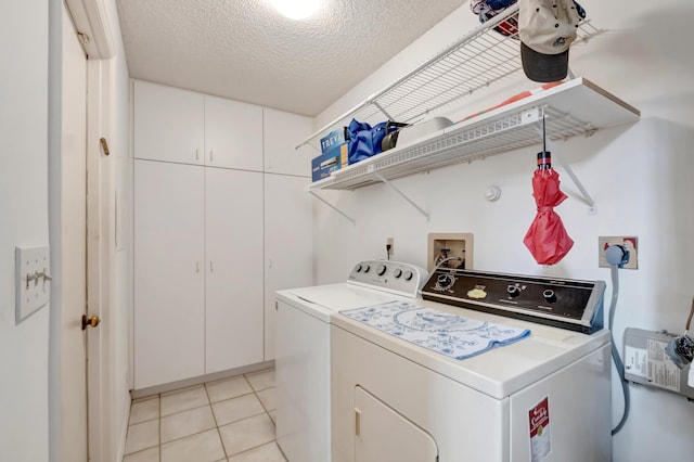 laundry room featuring independent washer and dryer, a textured ceiling, and light tile patterned floors