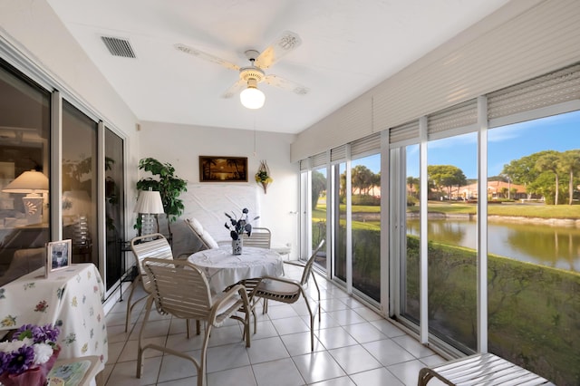 sunroom with ceiling fan and a water view