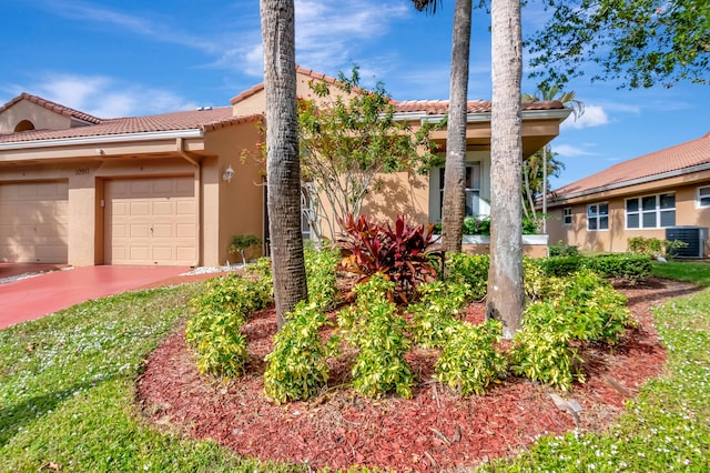 view of front of home featuring a garage and central air condition unit