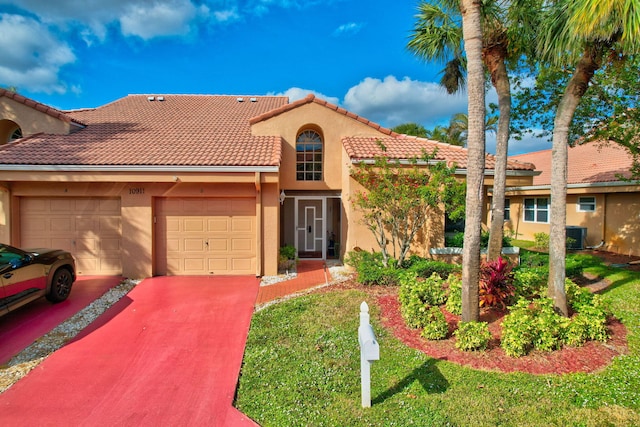 mediterranean / spanish-style home featuring a front yard and a garage