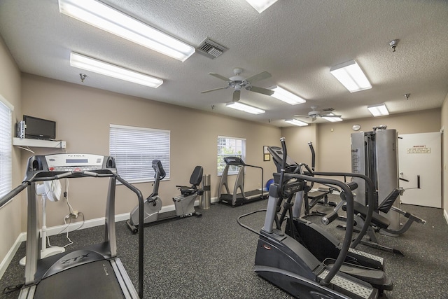 workout area featuring ceiling fan and a textured ceiling