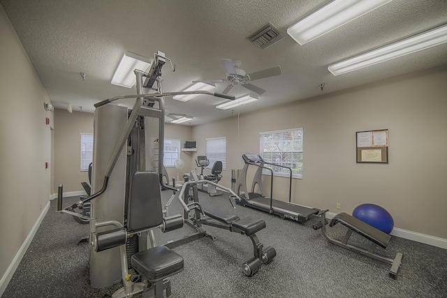 exercise room featuring ceiling fan and a textured ceiling